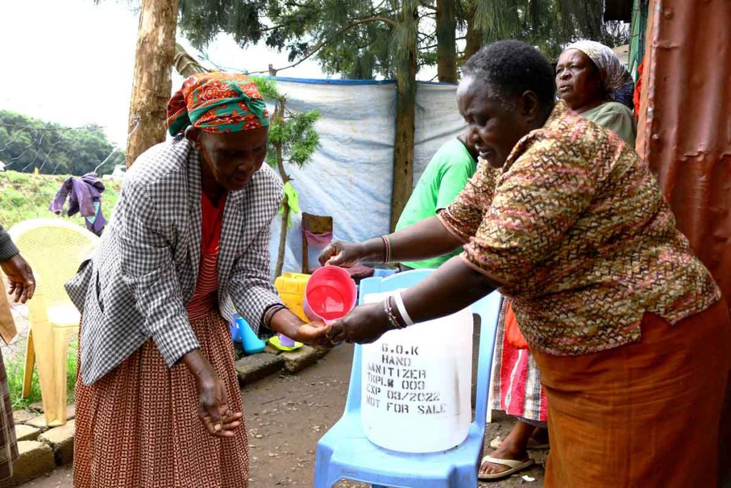 Agnes-Kariuki-L-demonstrates-how-a-government-of-Kenya-donated-hand-sanitizer-is-to-be-used.-1-2-1024×683